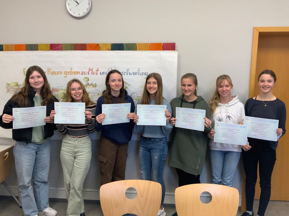 Auf dem Bild zu sehen sind (von links):  Olivia Selcuk (10a), Janina Münchow (9a), Antonia Beilner (9a), Cara Zenker (9a), Maya Sickmann (9a), Sonja Wenzel (9b) und Amelie Fischer (9b)  Nicht zu sehen, jedoch ebenso ausgezeichnet sind: Marie Termerson (8b), Louisa Sanelli (9a), Ilayda Yürekli (10b) und Pauline Unkelbach (ehemalige Schülerin) sowie Ronja Reuhl und Johanna Ruthardt 